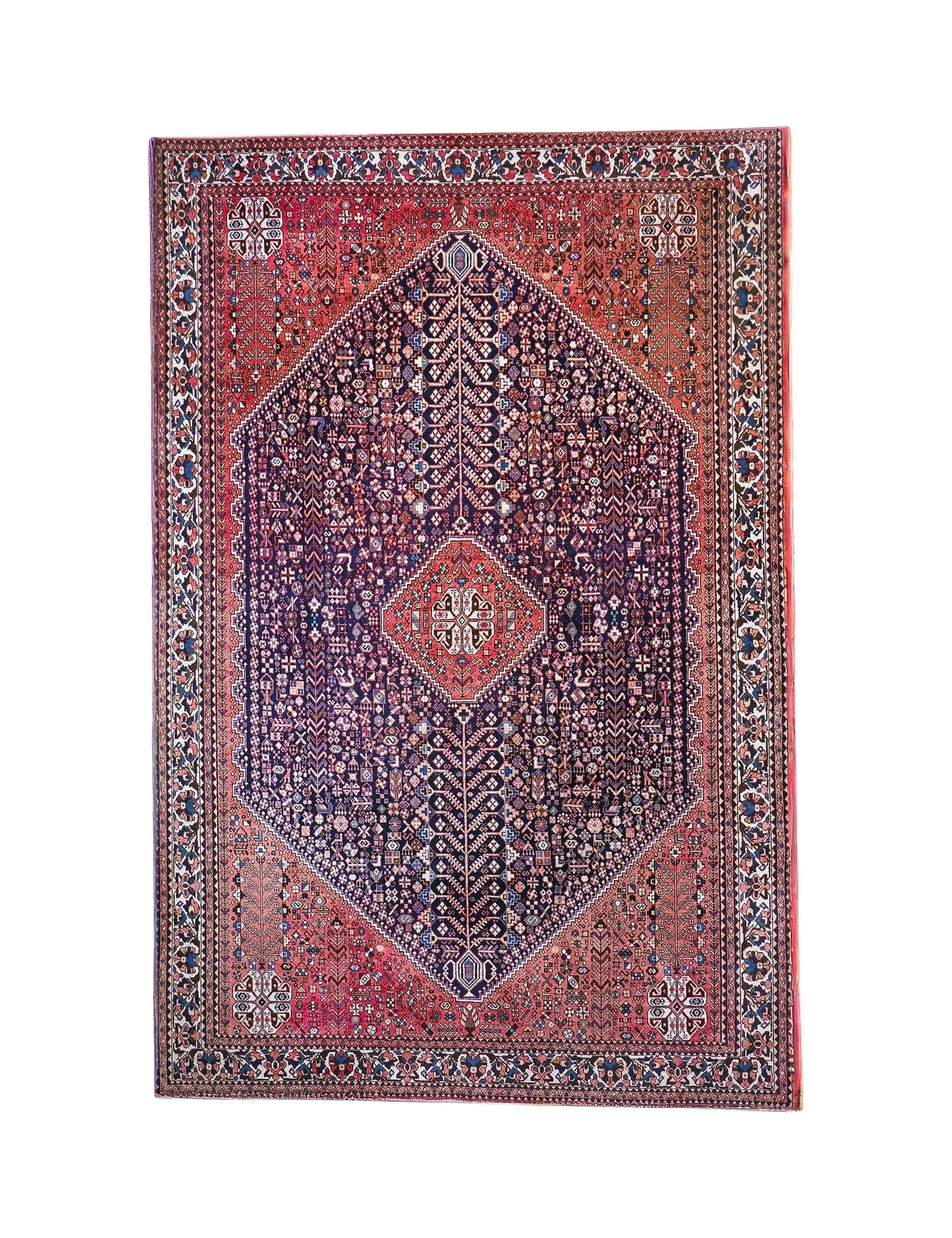 Full view Persian-style rug with red border, navy center, and diamond medallion