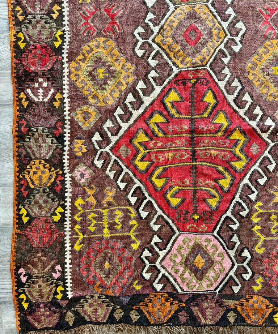 Kilim runner rug with maroon and gray geometric medallion pattern and fringe ends