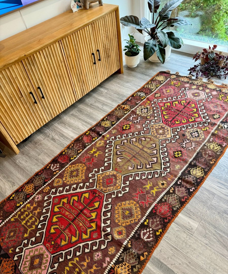 Kilim runner rug with red, brown, and gray geometric motifs and short fringe edges