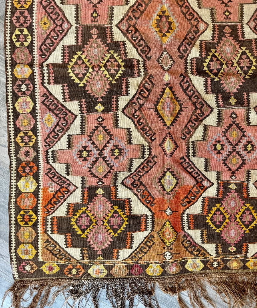 Kilim runner rug with multicolor geometric diamond pattern and short fringe trim.