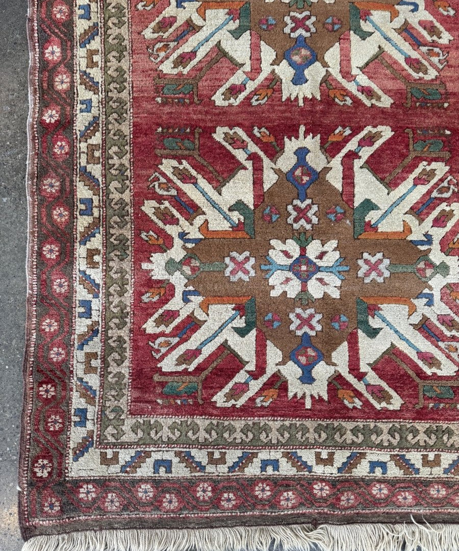 Turkish Kars rug with maroon center, ivory border, and geometric motif accents in blue and tan.
