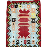Turkish kilim rug with red background, geometric diamonds, and zigzag border