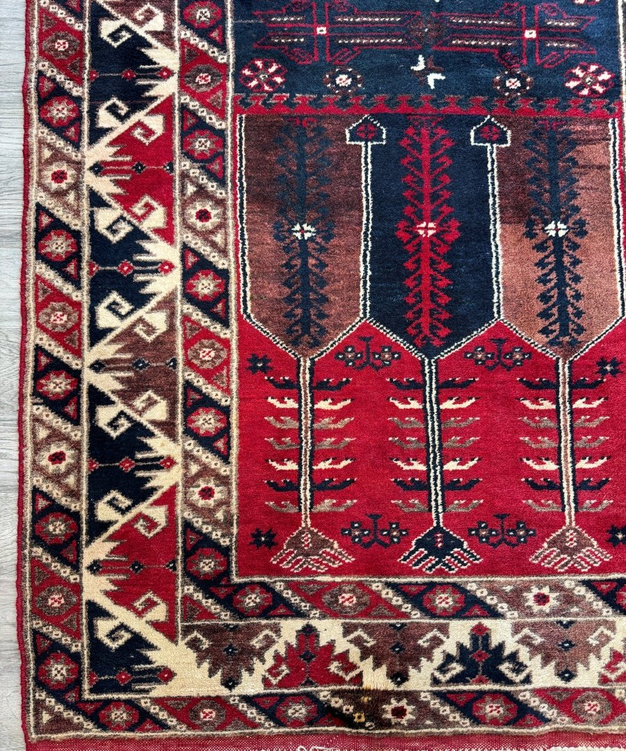 Turkish Konya rug with navy, red, and cream geometric medallion; fringed edges visible