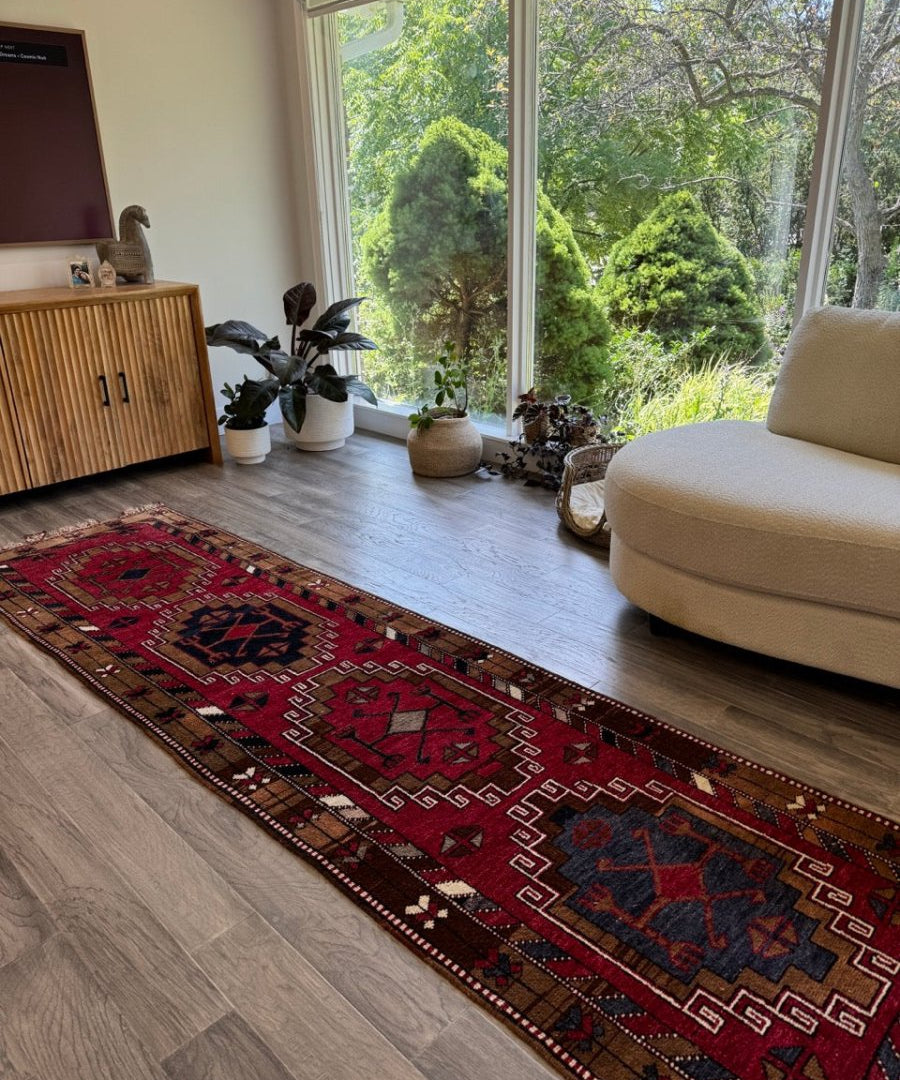 Runner rug with burgundy, navy, and cream geometric motifs along a contrasting border.