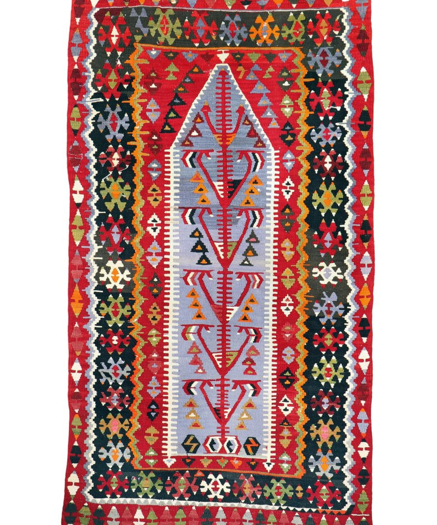 Turkish kilim rug on white background: red field, central white motif, and multicolor borders.