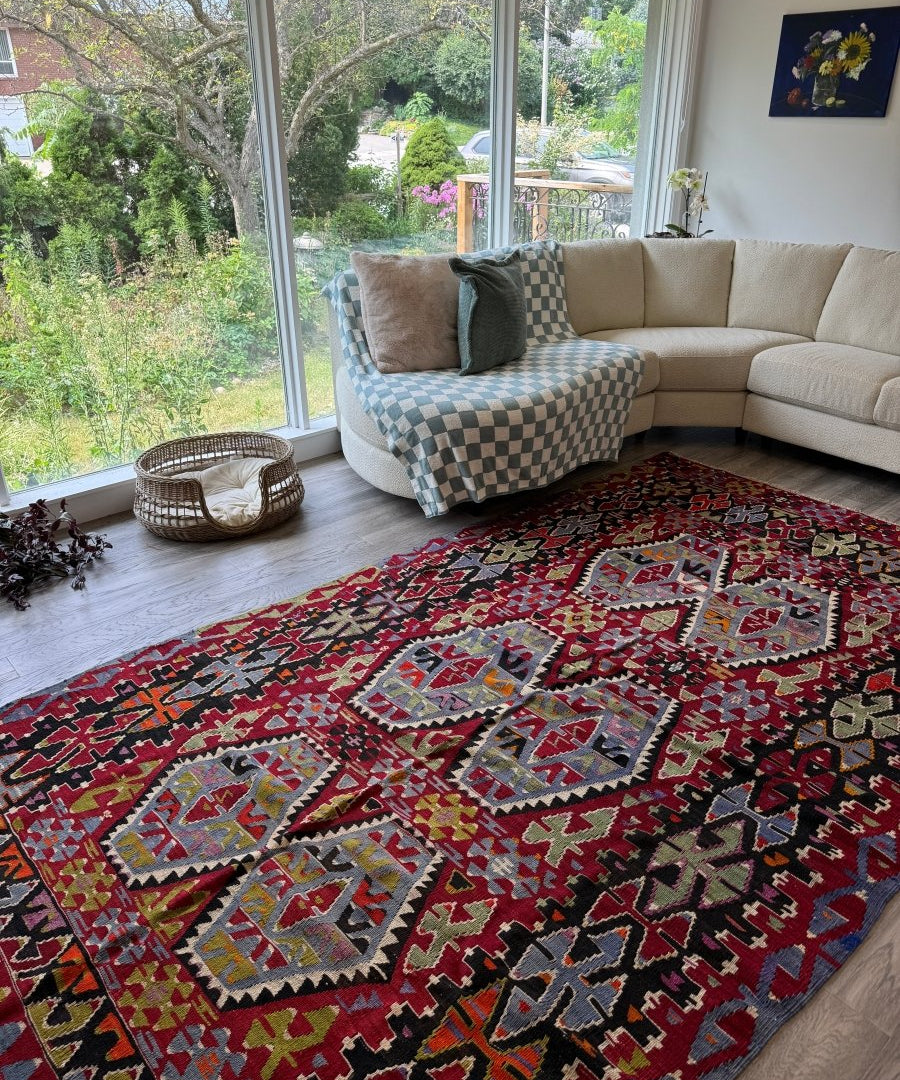 Red Turkish kilim area rug with central medallions and geometric borders in blue and cream