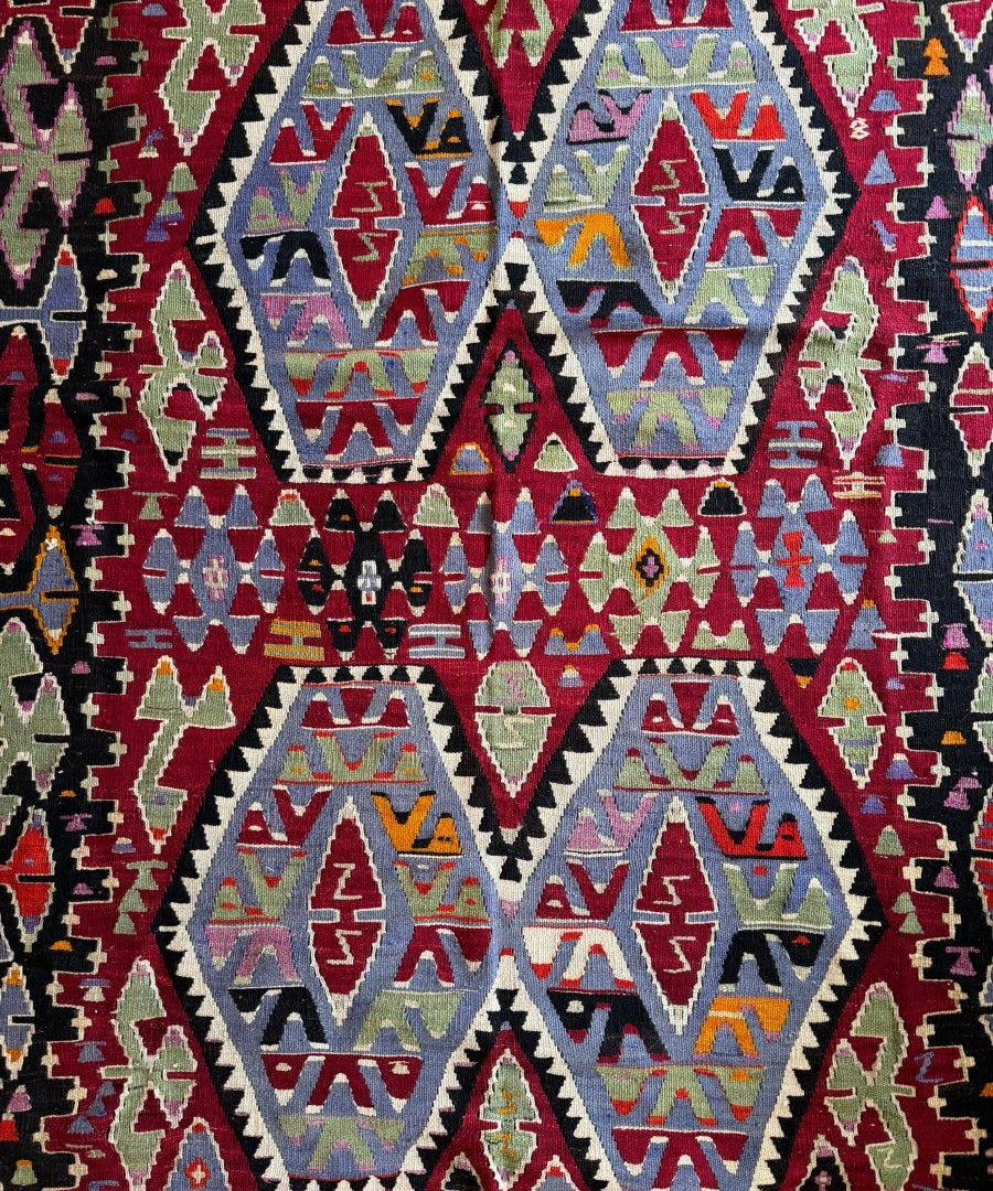 Geometric kilim rug with large diamond medallions in blue, cream, and red