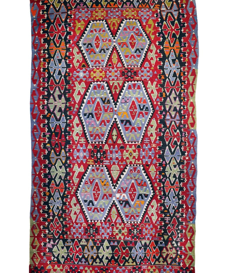 Rectangular red Turkish kilim rug with navy and cream tribal motifs and central medallions