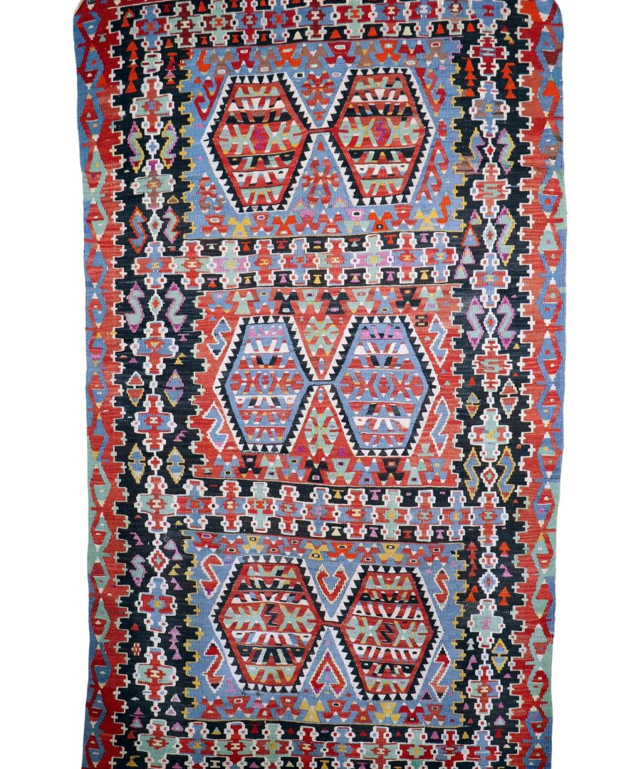 Geometric Turkish kilim rug with red border, blue accents, and central diamond medallions
