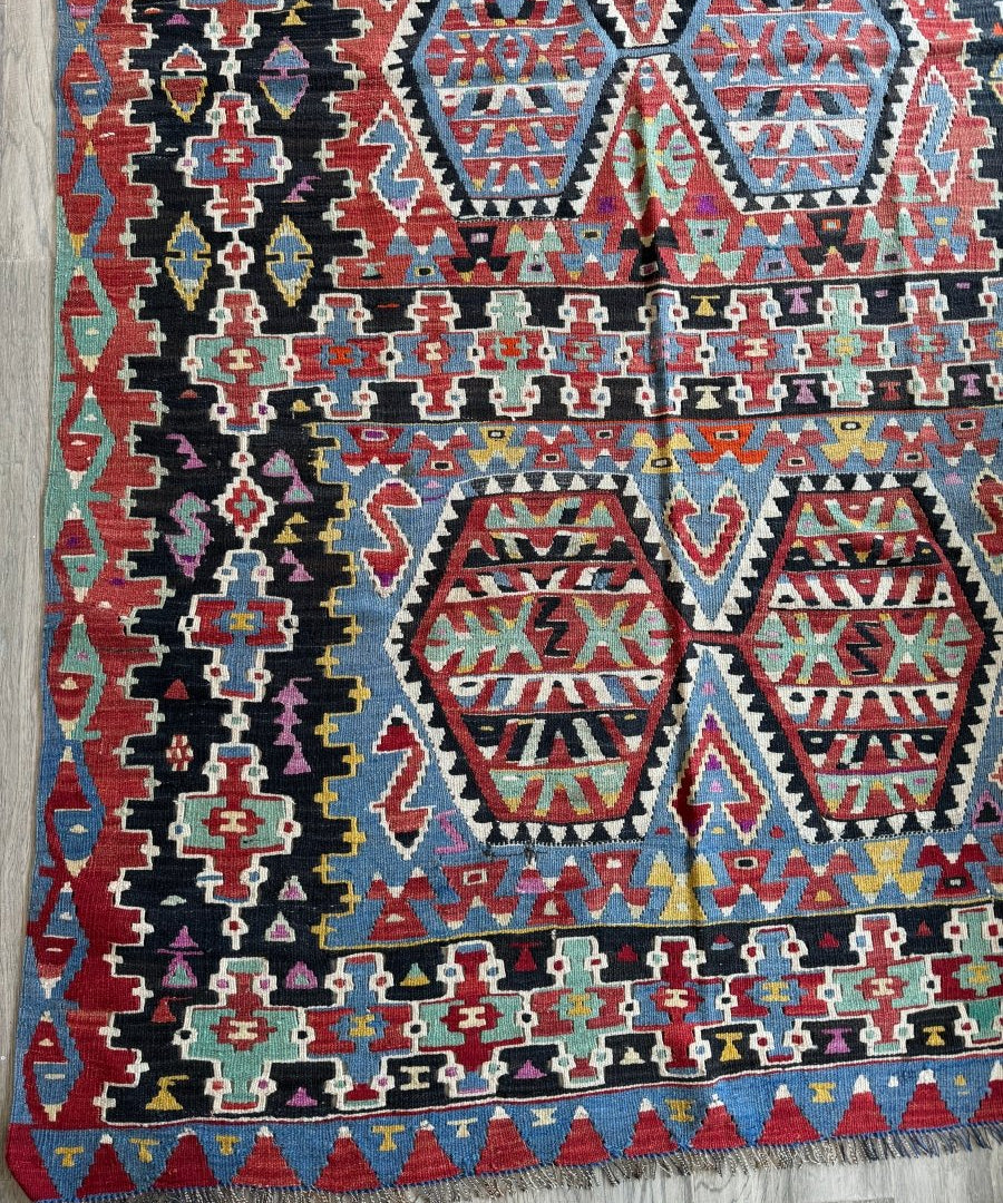 Geometric Turkish kilim rug with red, blue, black, and beige diamond motifs