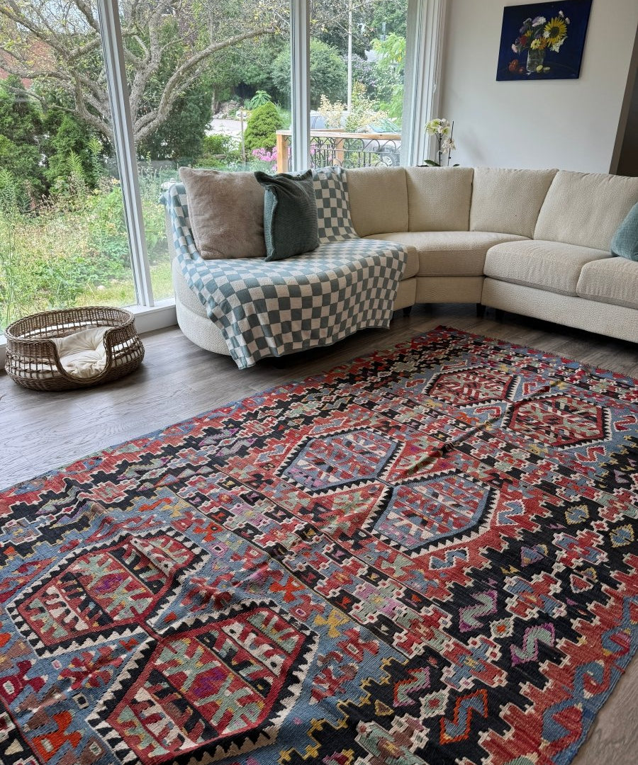 Geometric Turkish kilim rug with red and black central medallion and multicolor accents