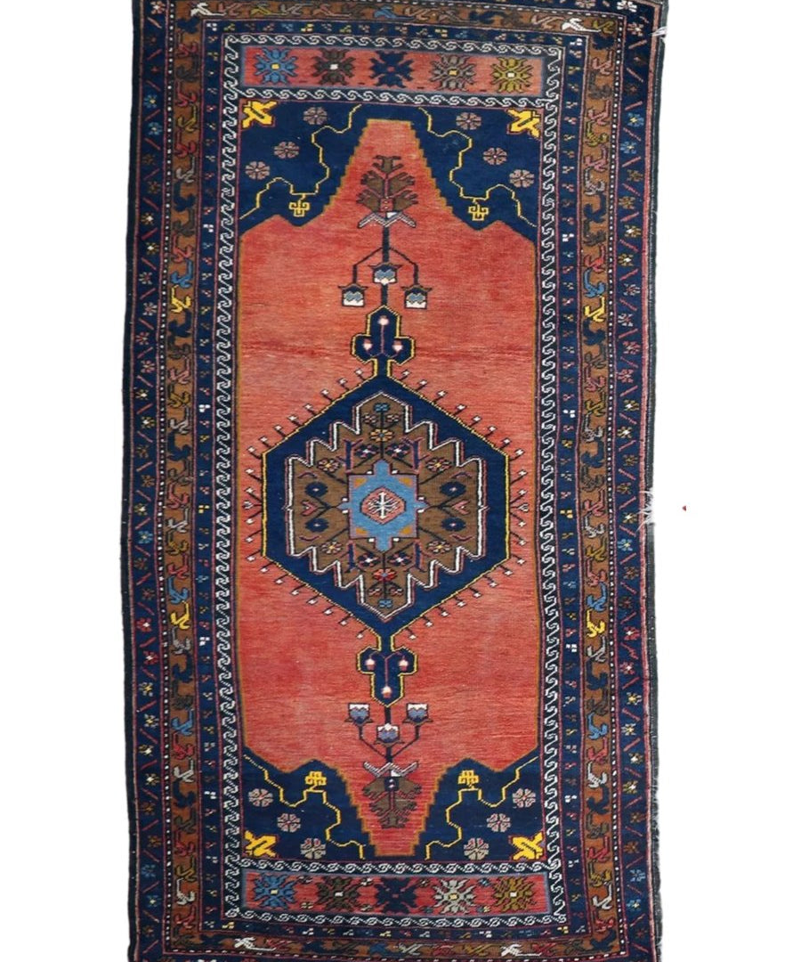 Rectangular rug on white background with red center medallion and navy border stripes.