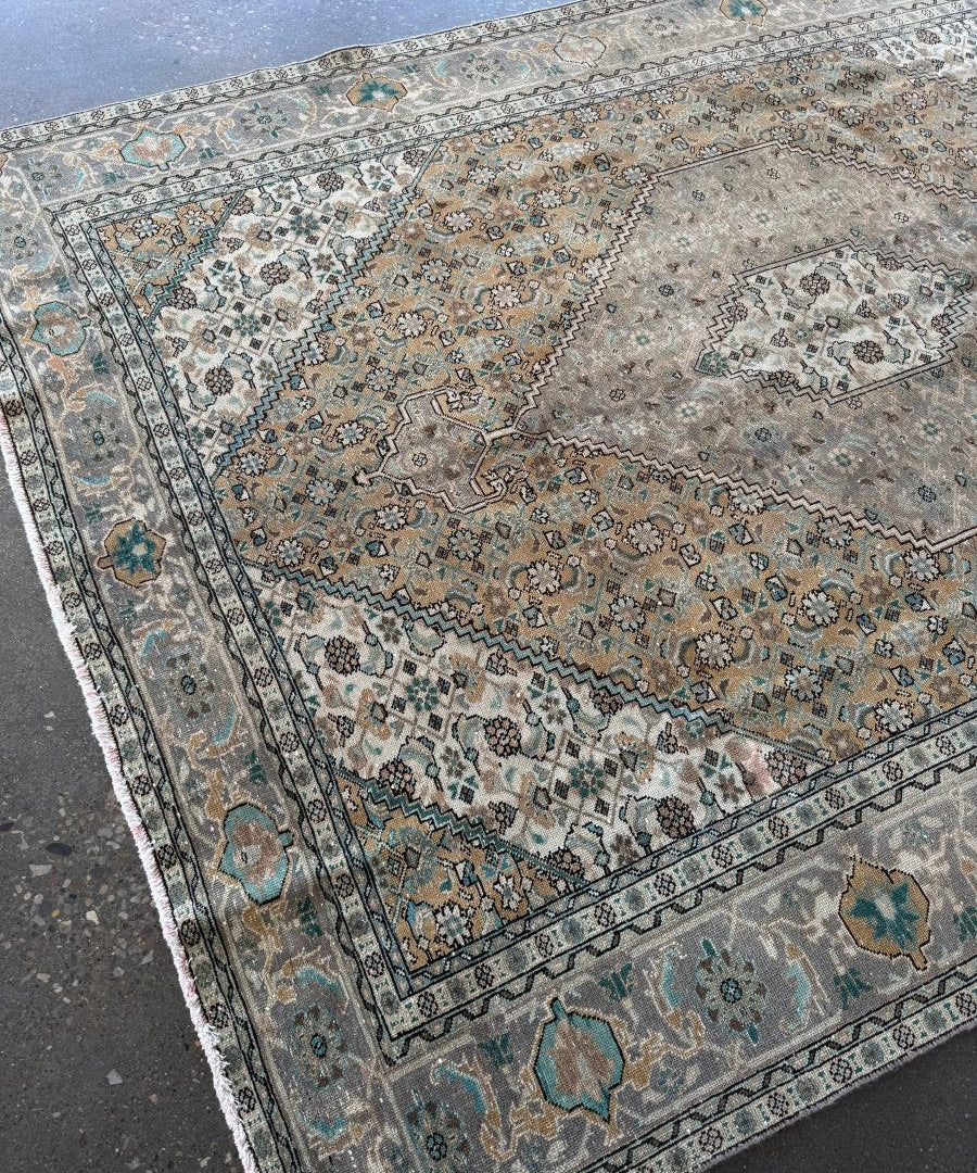 Ardabil-style vintage rug corner with blue border stripe and ornate tan and teal motifs