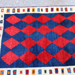 Red diamond pattern Gabbeh rug with navy field and white side border
