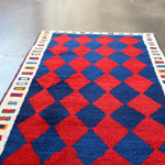 Vintage Persian Gabbeh rug in red and navy with cream border and diamond grid