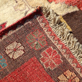 Corner edge of Persian Gabbeh rug with fringe and detailed border weave pattern.