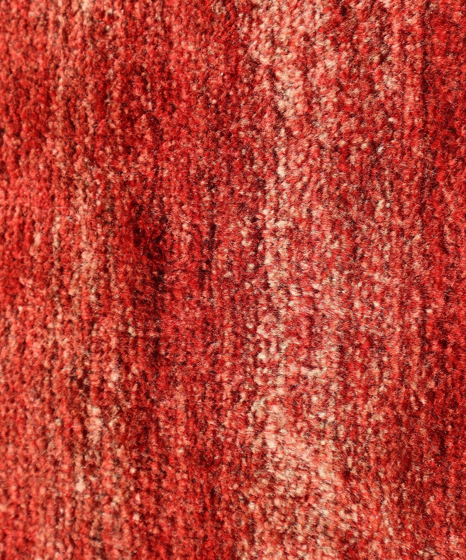 Red Persian Gabbeh rug surface texture in dense looped pile with subtle mottling.