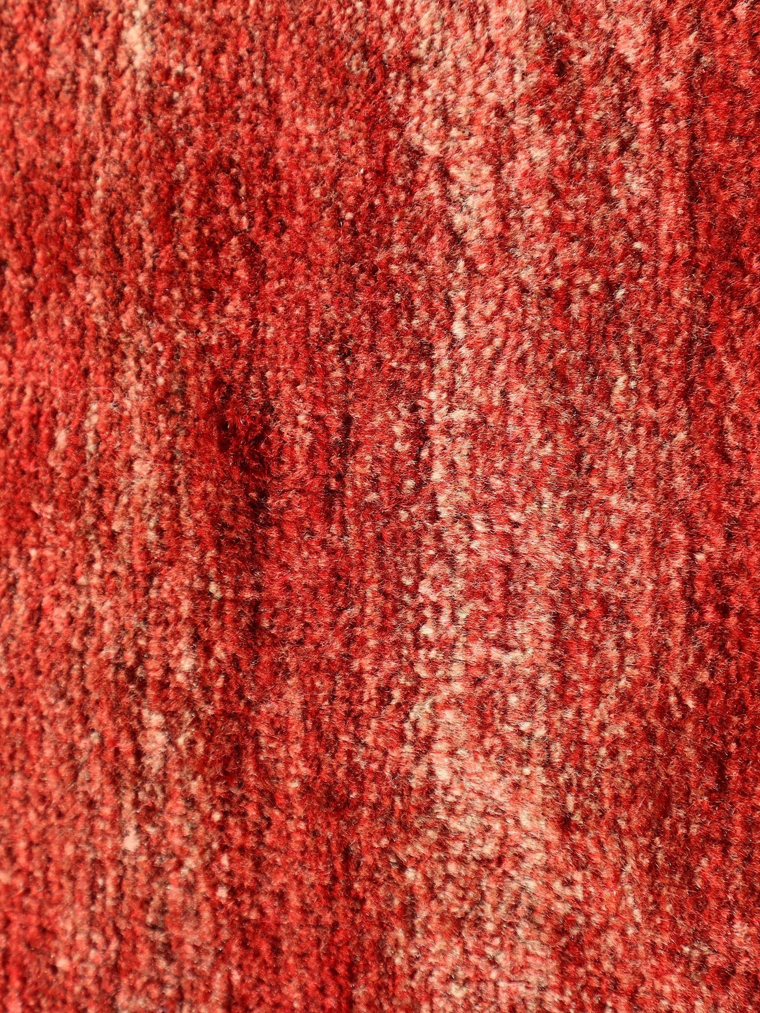 Red Persian Gabbeh rug surface texture in dense looped pile with subtle mottling.