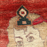 Close-up portrait motif on a red Persian Gabbeh rug with cream figure and dark accents.