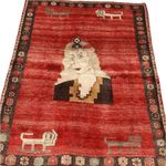 Full view vintage Persian Gabbeh rug with red field, cream portrait, and dark floral border.