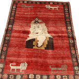 Full view vintage Persian Gabbeh rug with red field, cream portrait, and dark floral border.