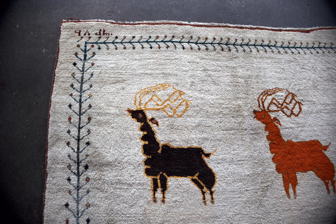 Ivory gabbeh rug section with two animal figures in brown and orange, navy outline.