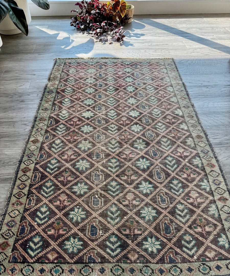 Vintage geometric rug with diamond lattice pattern in teal, tan, and rust tones