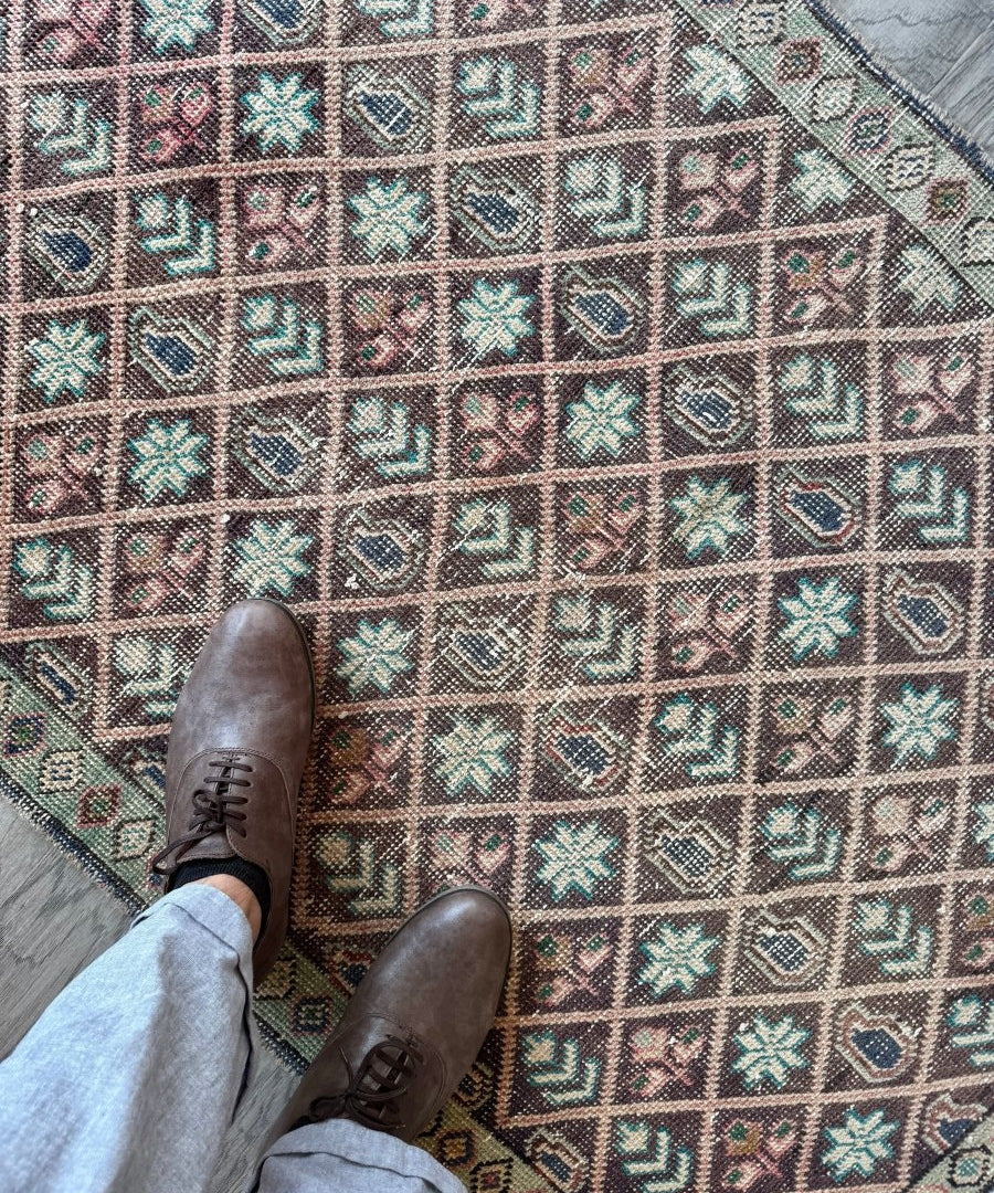 Geometric diamond vintage rug with teal, beige, and rust accents