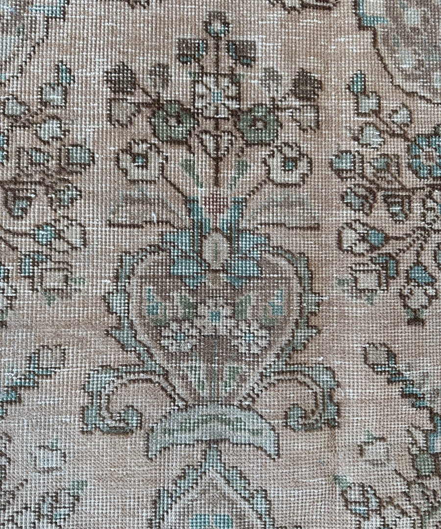 Vintage Tabriz rug close-up of blue geometric and floral pattern on cream weave