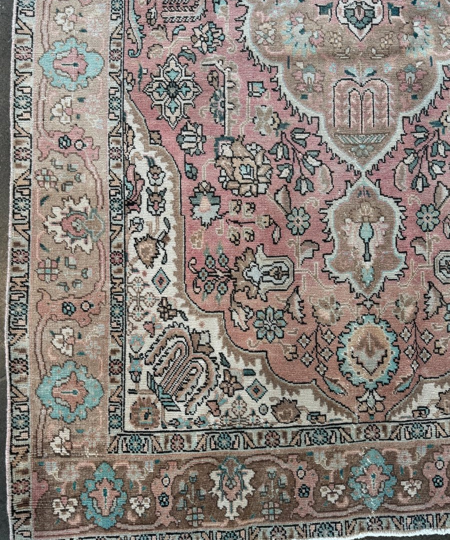 Vintage Tabriz rug with pink center medallion, teal floral border, fringed edge