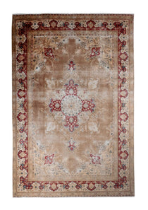 Ivory Tabriz-style area rug with red and blue corner ornaments and center medallion.