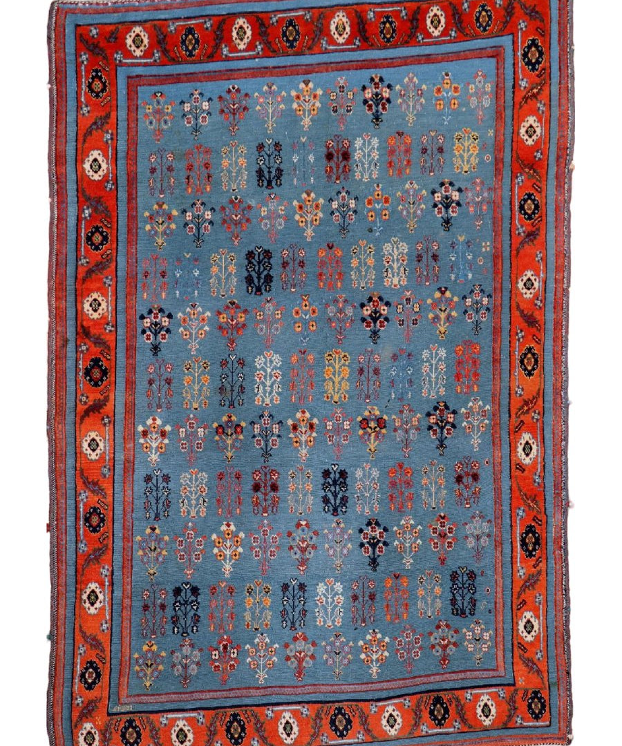 Gabbeh-Kilim rug with blue field, red border, and repeating geometric medallion motifs