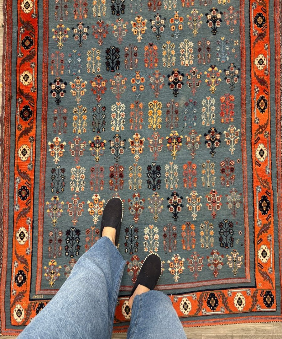 Blue Gabbeh-style kilim rug with red border and scattered floral medallion motifs