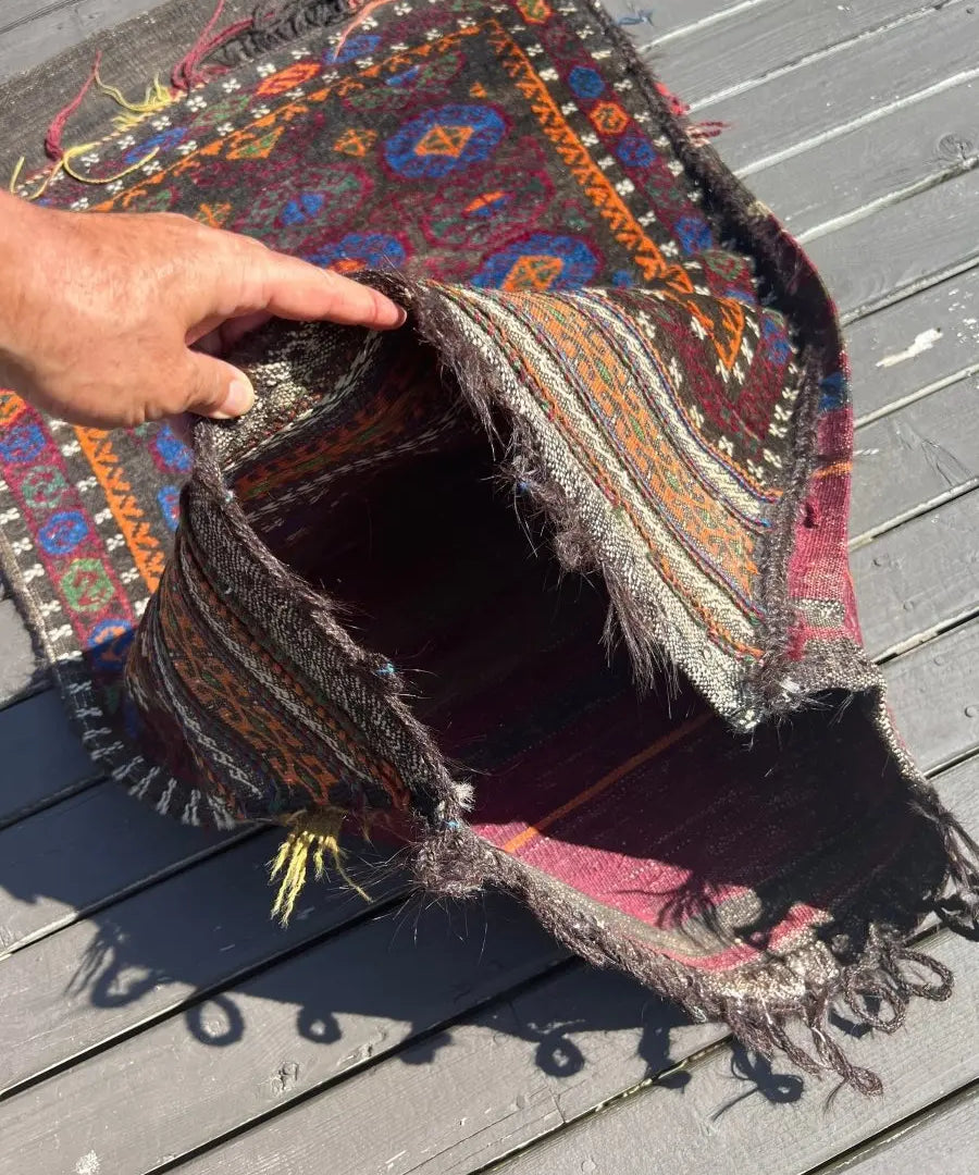 Baluch saddlebag rug open top showing patterned lining and fringed edge