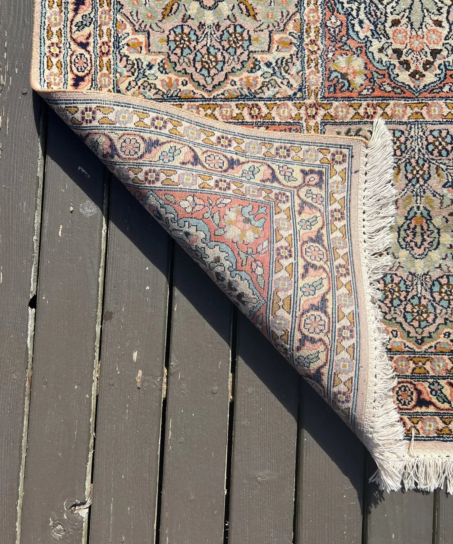 Indian Kashmir rug corner detail, ornate border and floral motifs, short fringe