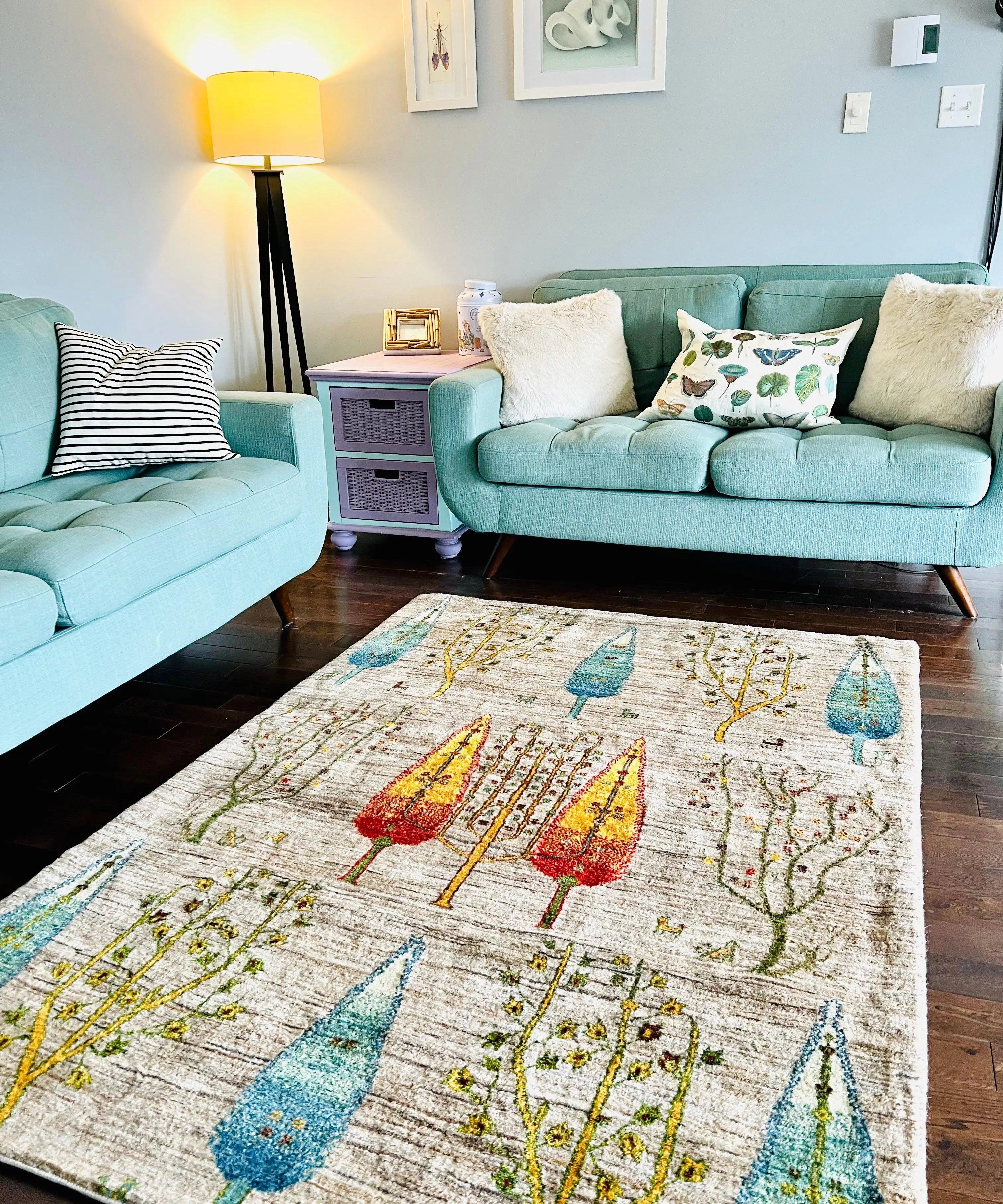 Area rug with light background and colorful tree and garden motif