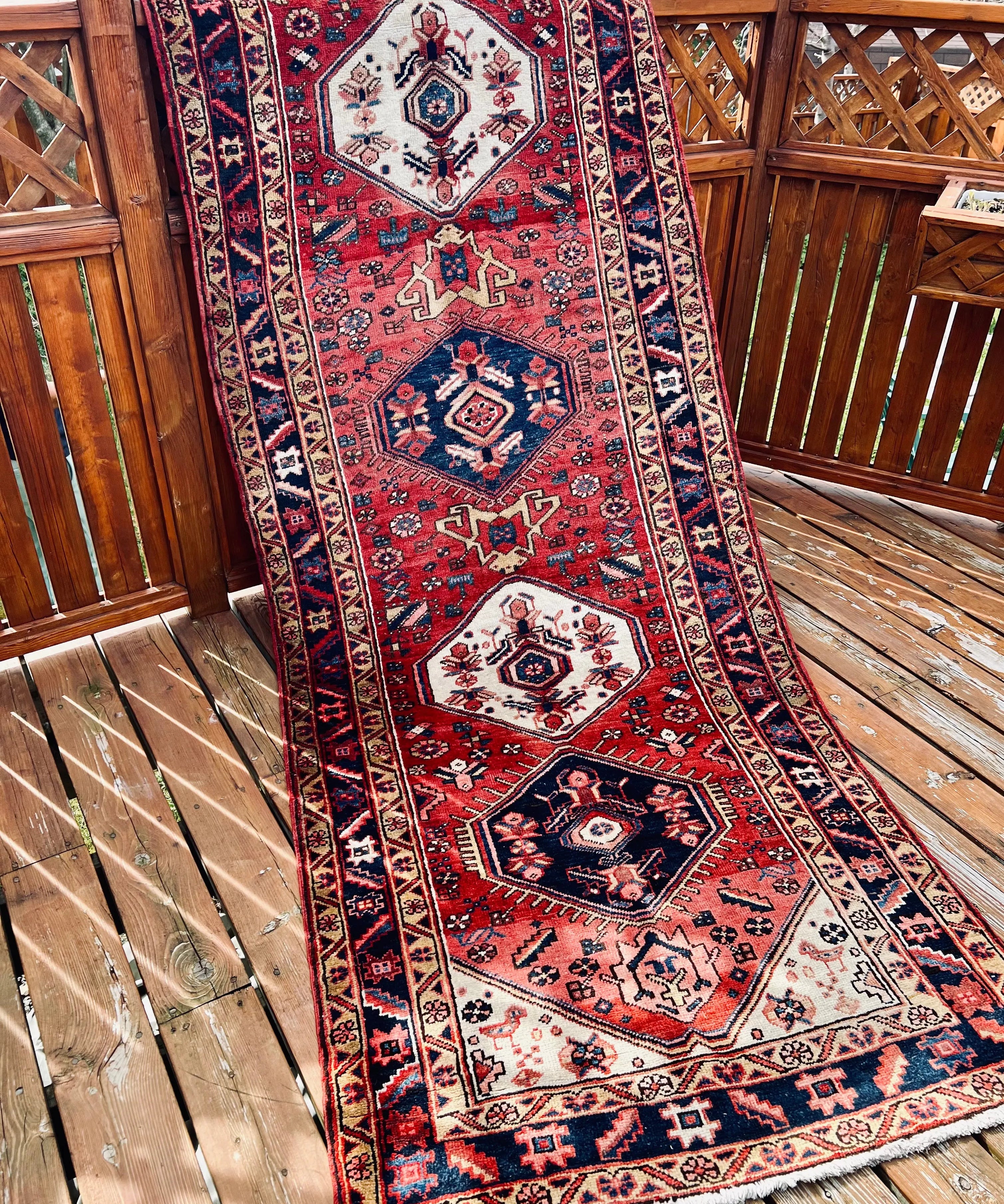 Persian Heriz runner rug with red, navy, and white geometric medallion pattern