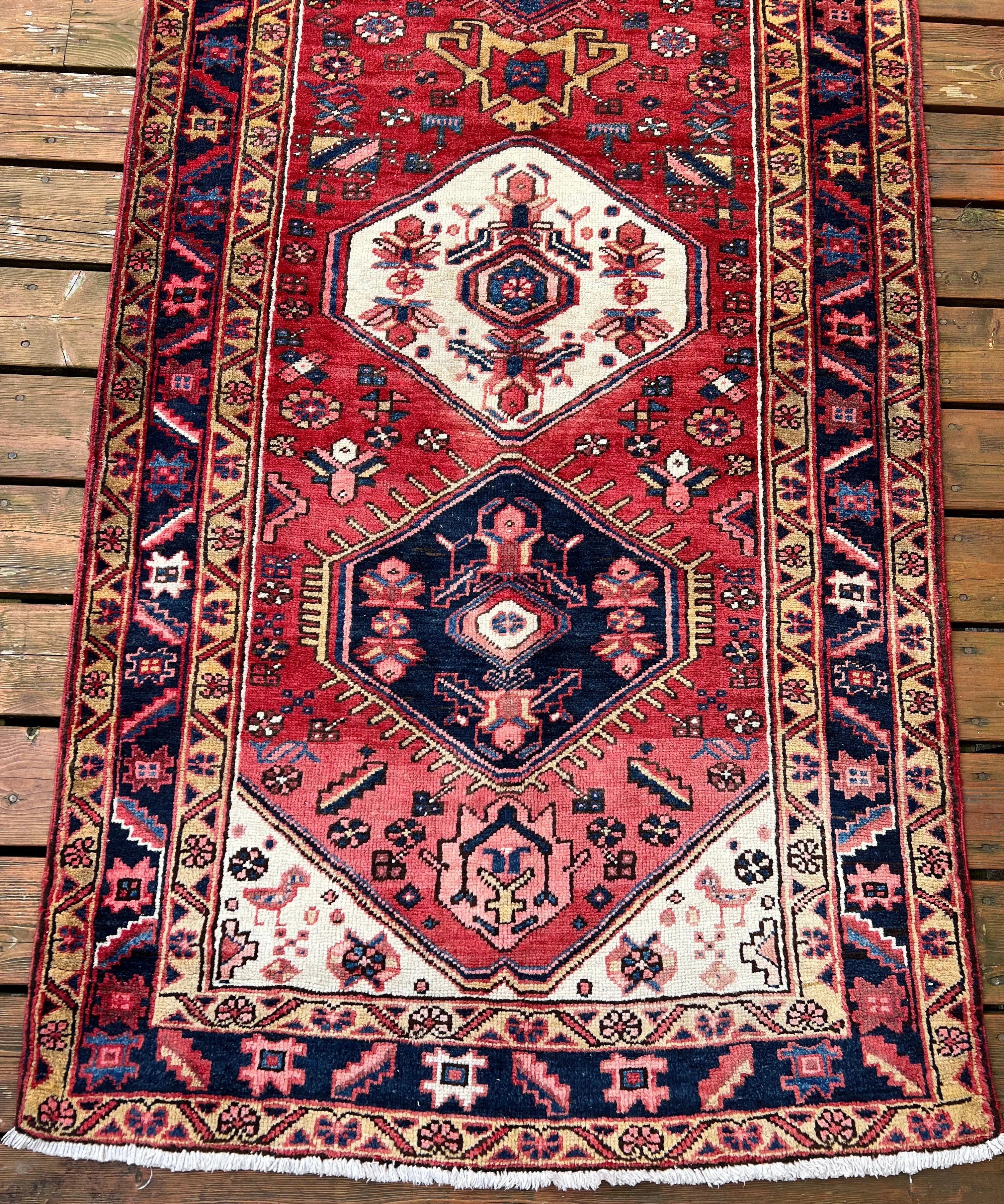 Persian Heriz runner rug, red field with white diamond medallions and navy borders