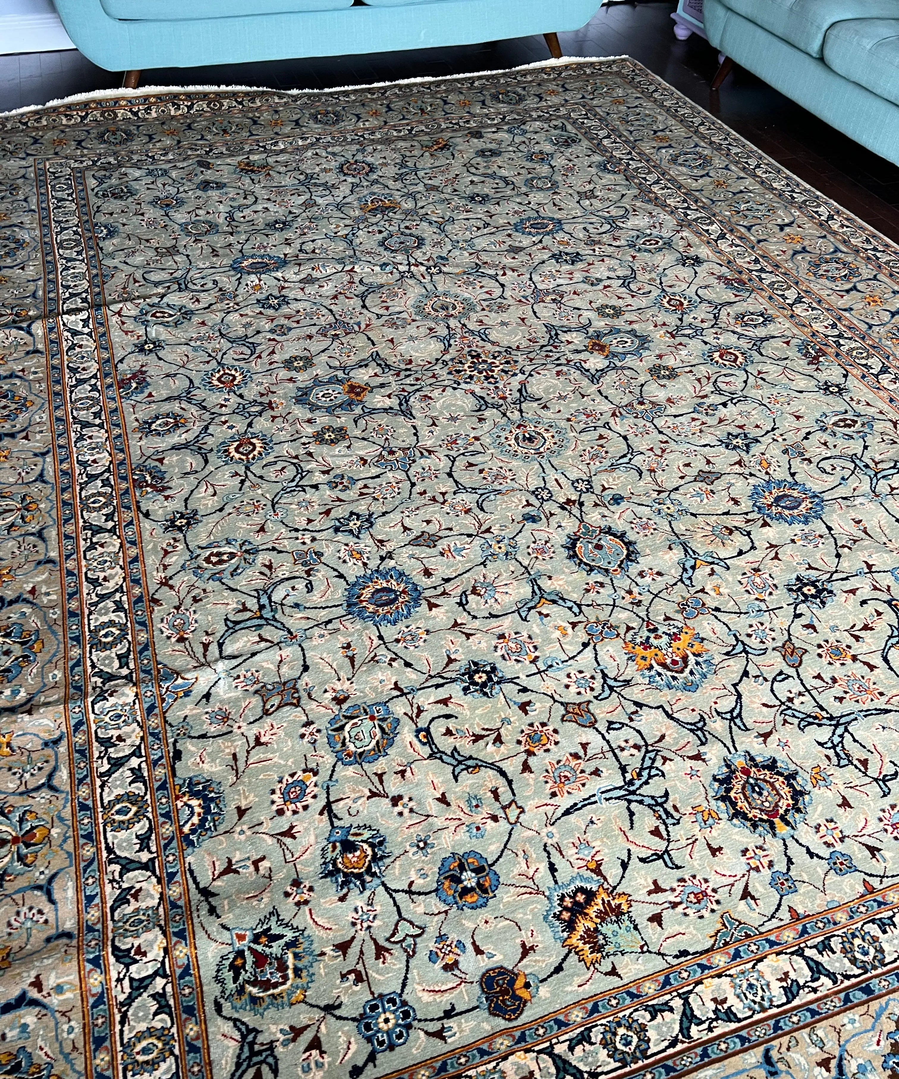 Persian Kashan rug with ivory background, blue vine motifs, central medallion and border