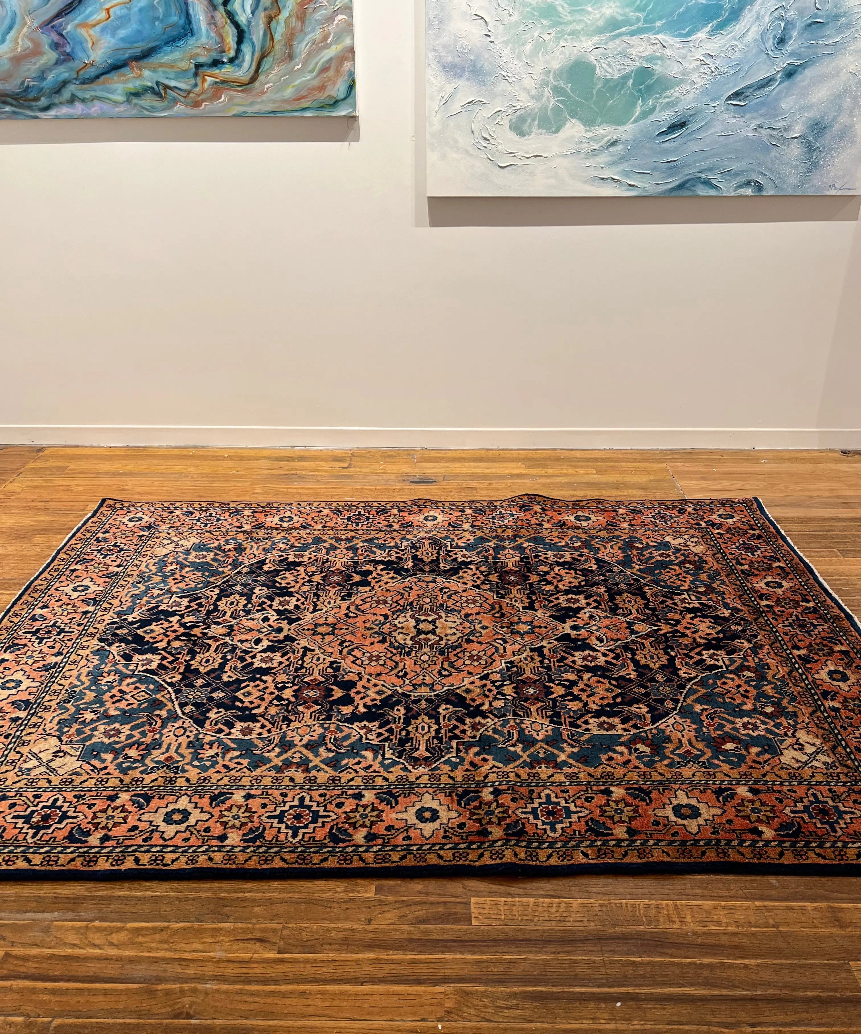 Ornate Persian-style area rug with dark blue and rust medallion, border and accents.