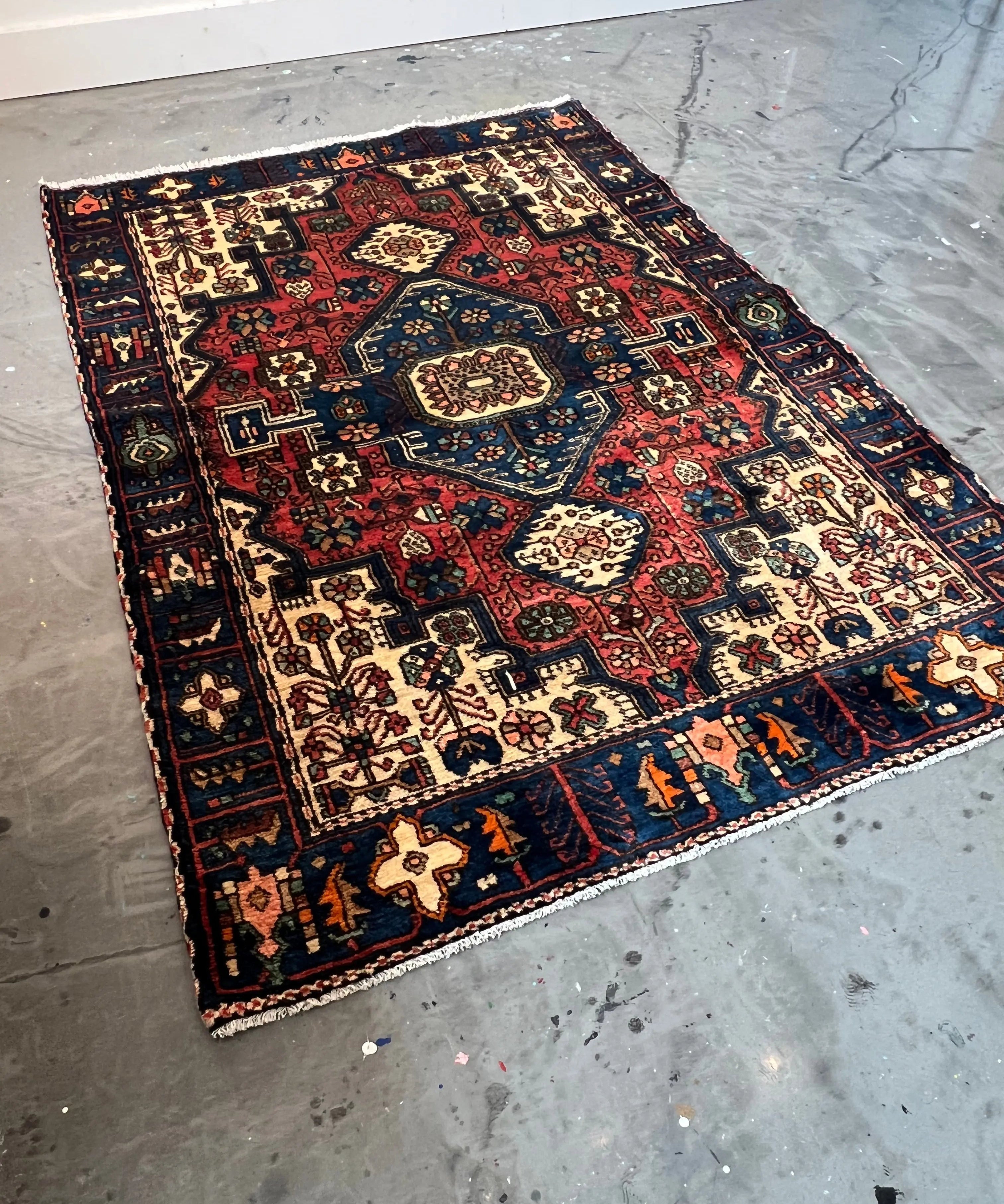 Persian Nahavand rug with navy, red and cream geometric motifs, bordered design