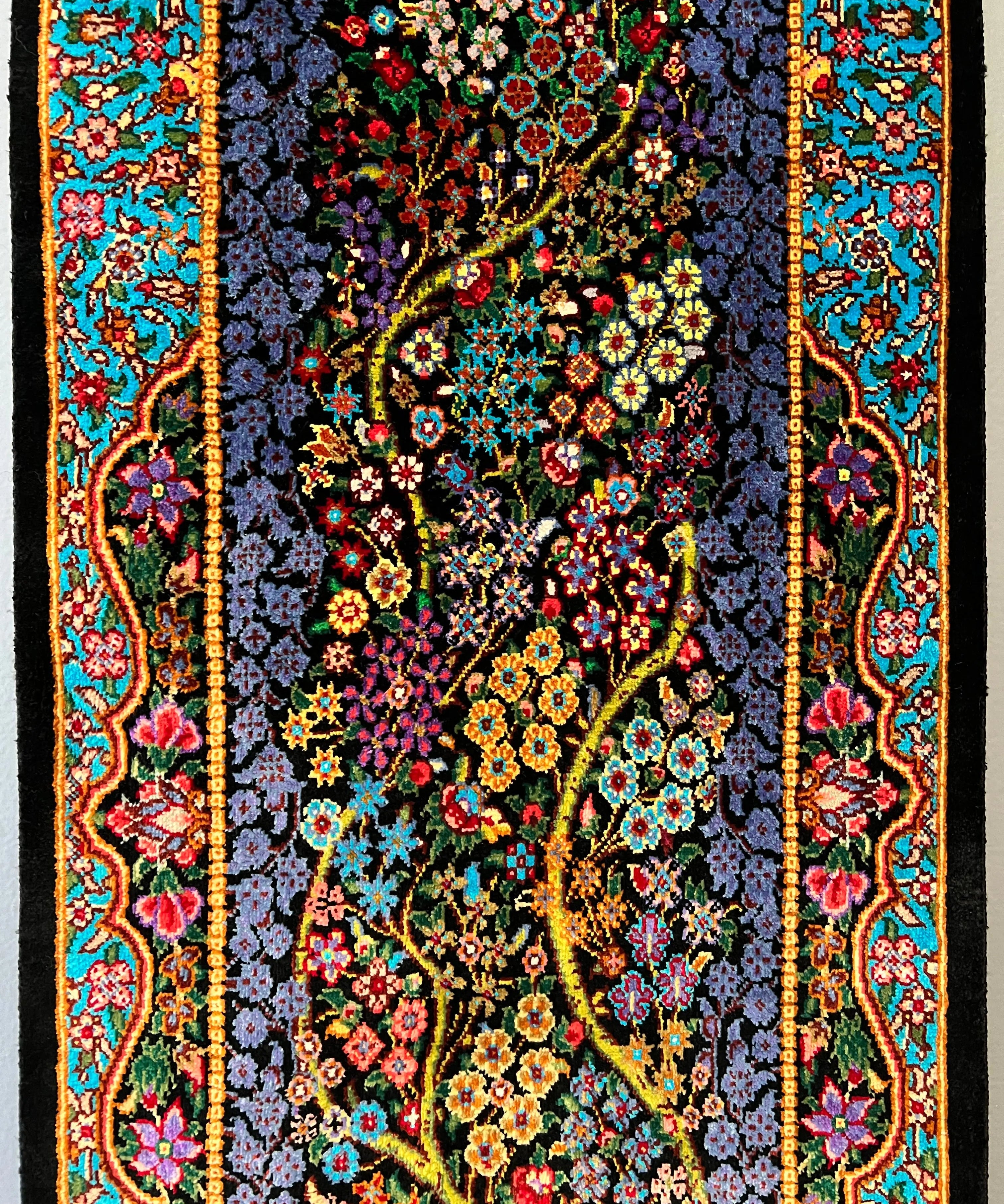 Silk tableau rug, dark navy floral pattern with ornate teal and red border, fringed edge