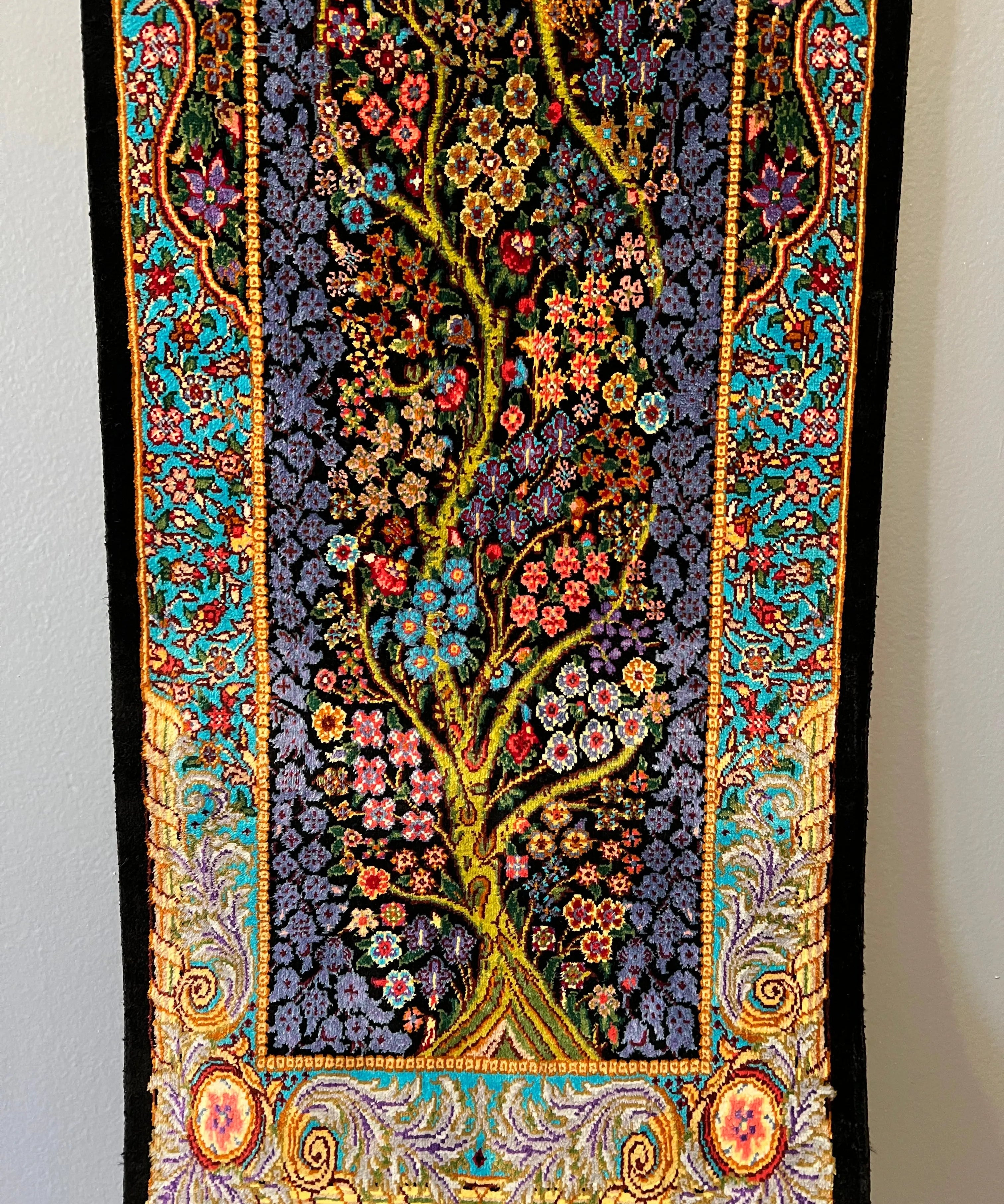 Silk tableau rug close view of bottom border, dark floral center, teal red and gold edging