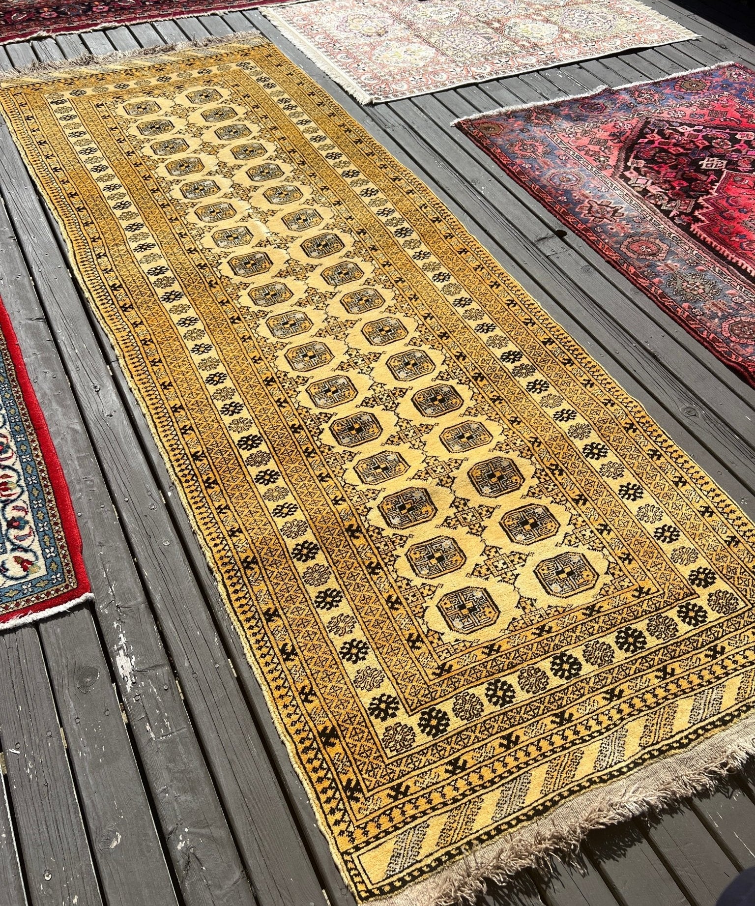 Afghan Bokhara runner rug with black medallion lattice, patterned border, and short fringe
