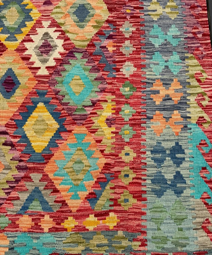 Multicolor kilim rug with dense geometric diamonds and stripe motifs, close-up