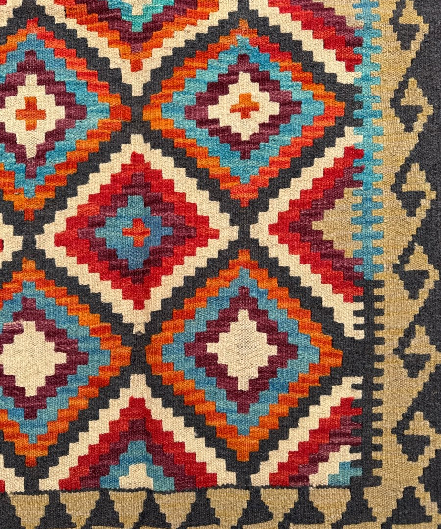 Kilim runner rug close-up with diamond motifs, multicolor border, and short fringes