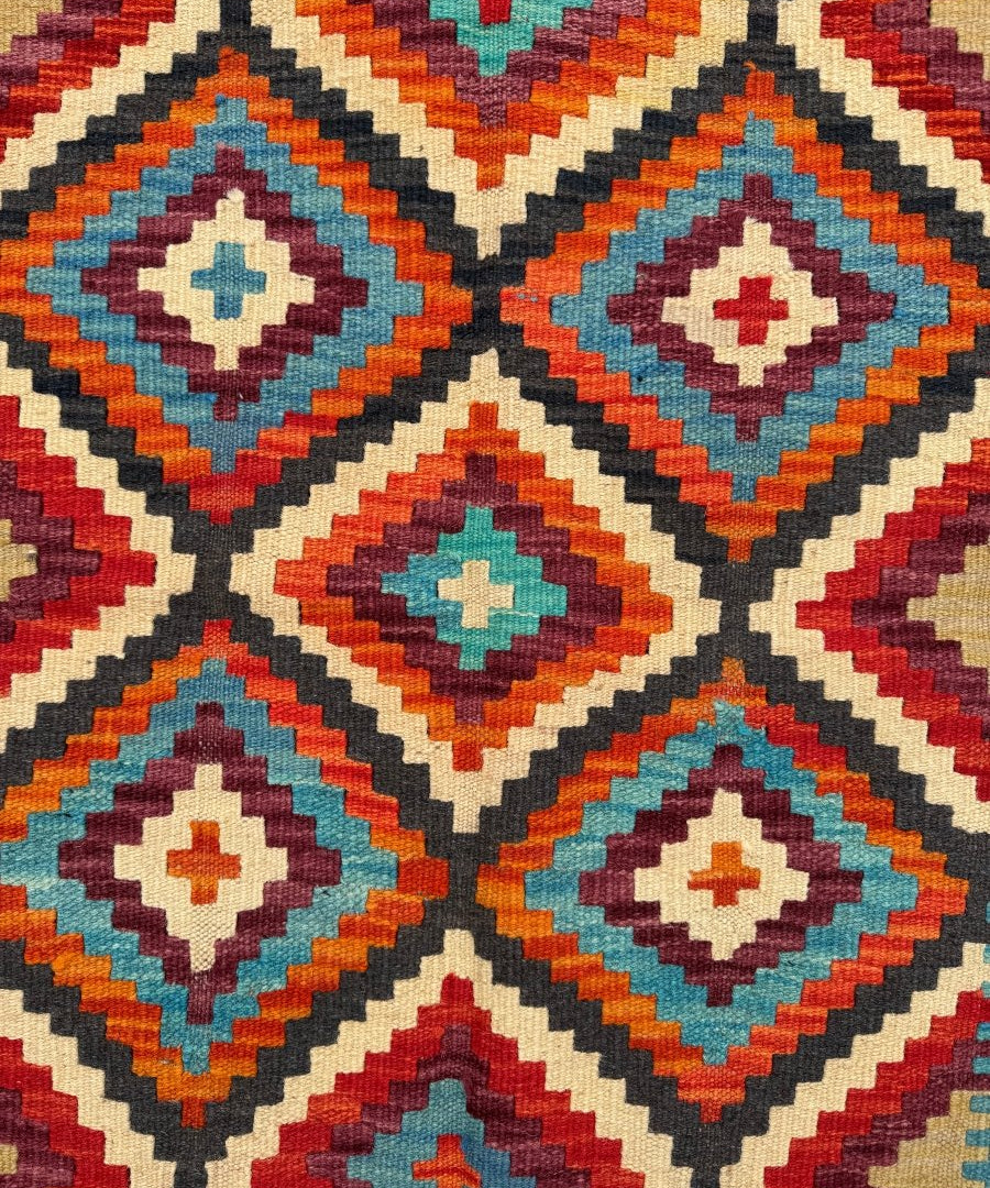 Kilim runner rug close-up of diamond motifs in teal, red, orange, and cream