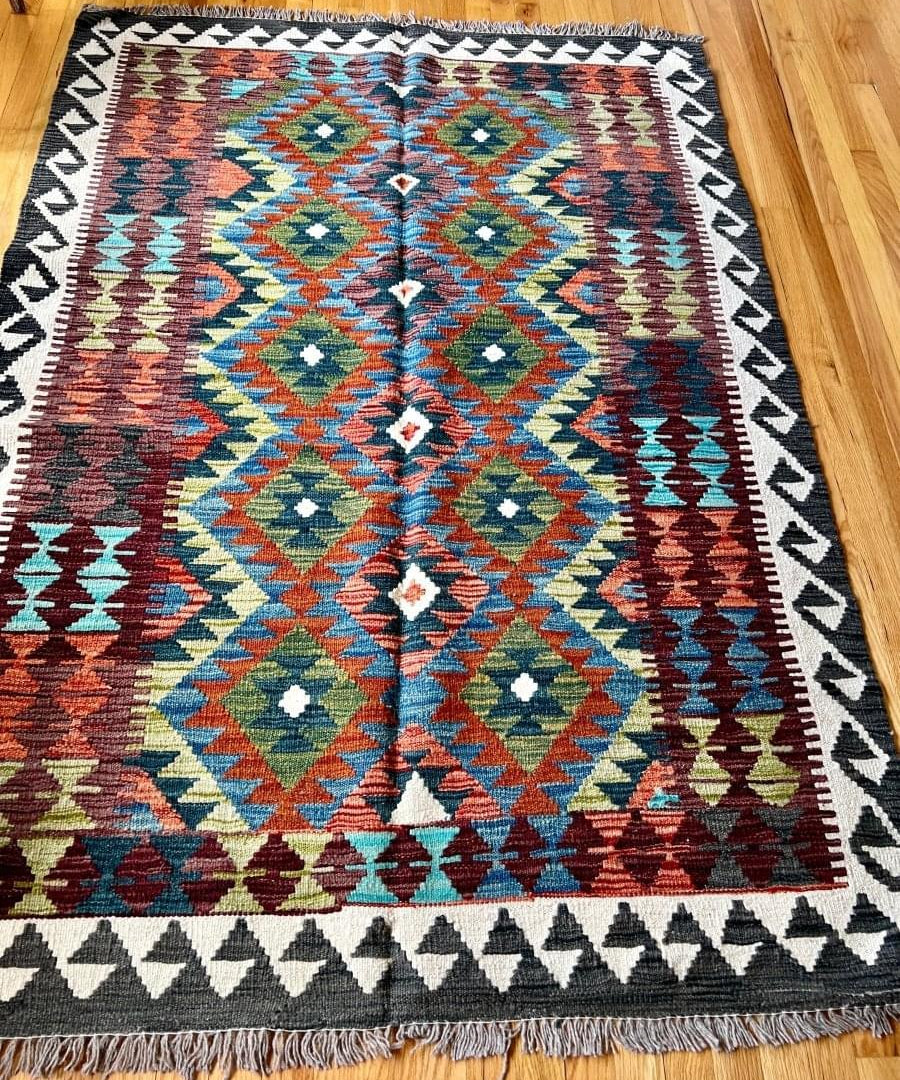 Afghan kilim rug with center diamond medallion and multicolor geometric border