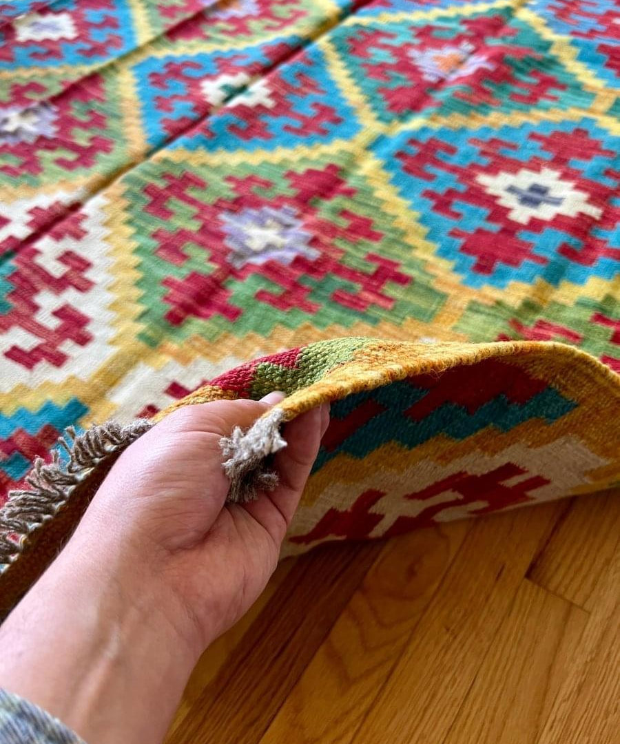 Kilim rug corner with fringed edge and geometric motif in multicolor