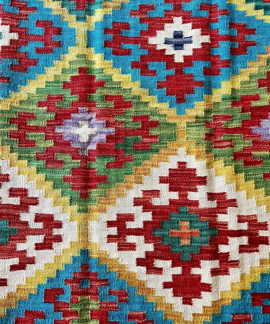 Kilim rug close-up of cross and diamond motifs in blue, red, green, white